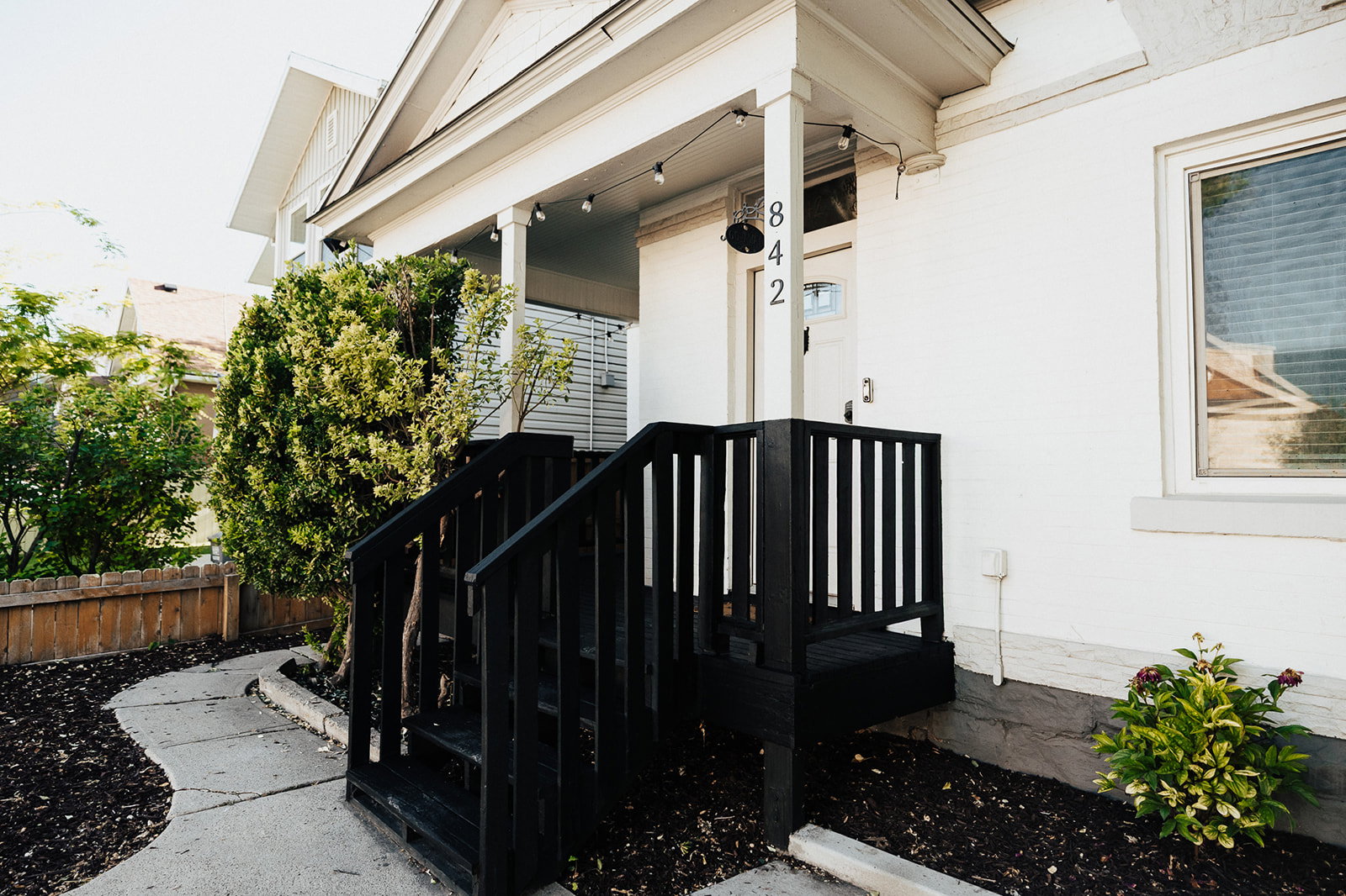 Inviting front porch with black painted railings and steps