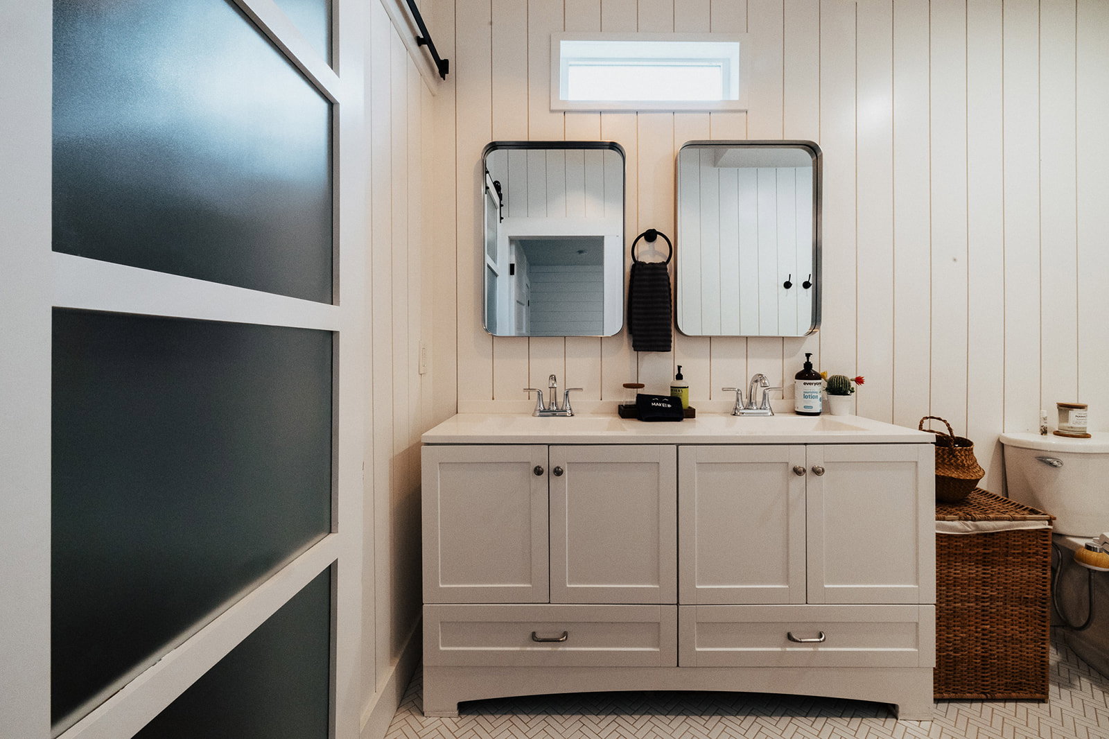 Double vanity with undermount sinks and chrome fixtures, framed by two rectangular mirrors