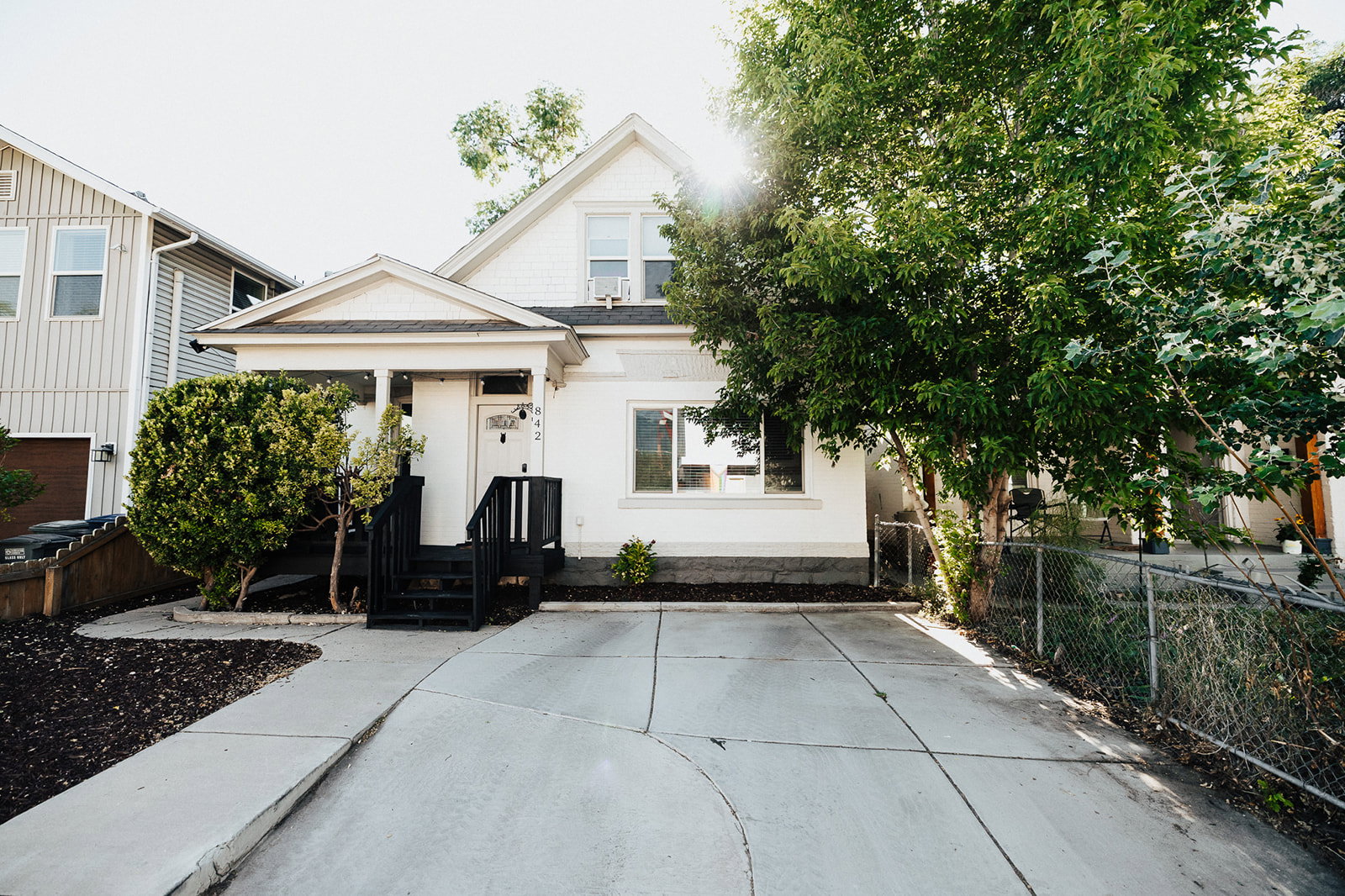 White exterior home featuring a covered front porch with dark-stained steps