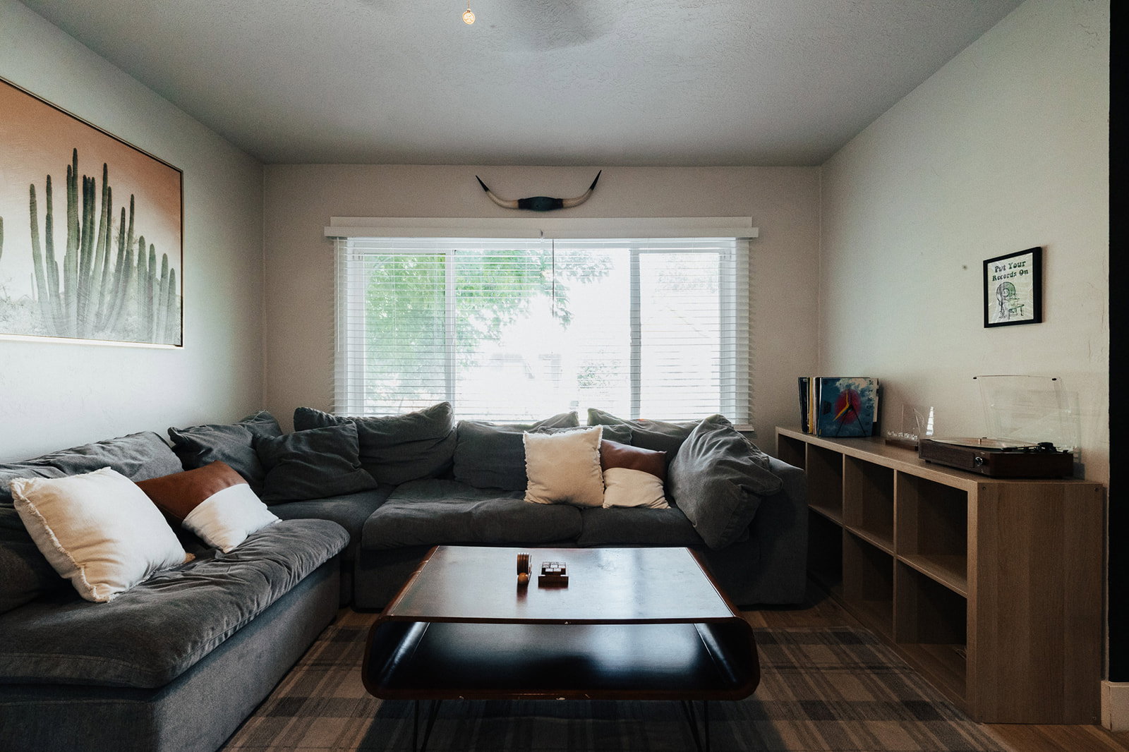 Living area featuring recessed lighting, a large window with white blinds, and light-toned wood-finish flooring