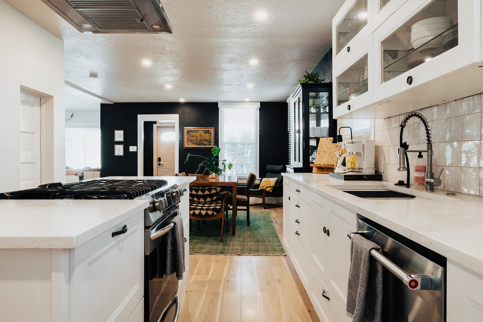 Contemporary kitchen featuring white cabinetry, light countertops, and light wood-finish flooring