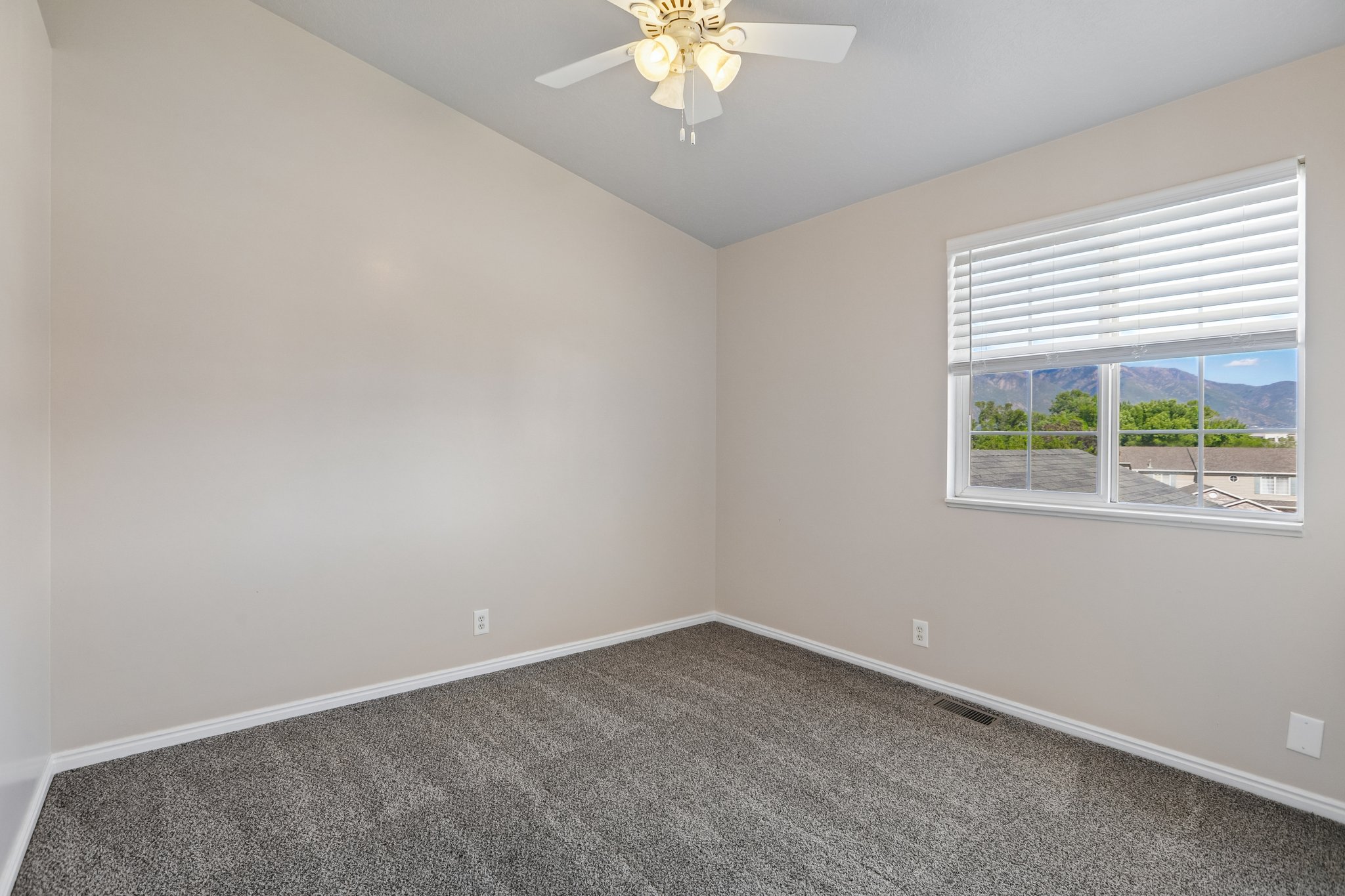 Room featuring vaulted ceilings, neutral wall tones, and gray carpet flooring
