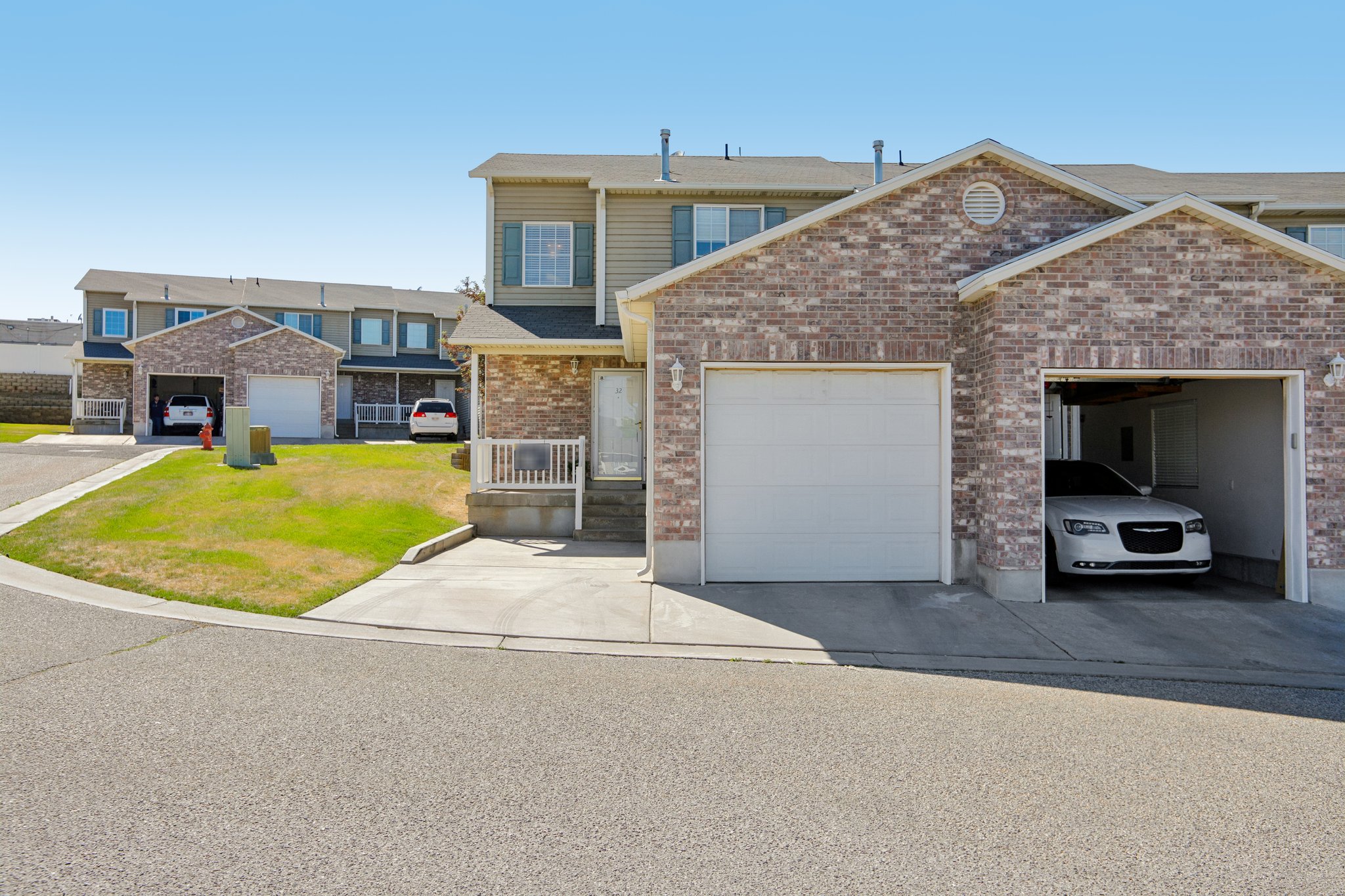 Townhome exterior featuring brick and siding finishes, an integrated single-car garage, and a concrete driveway