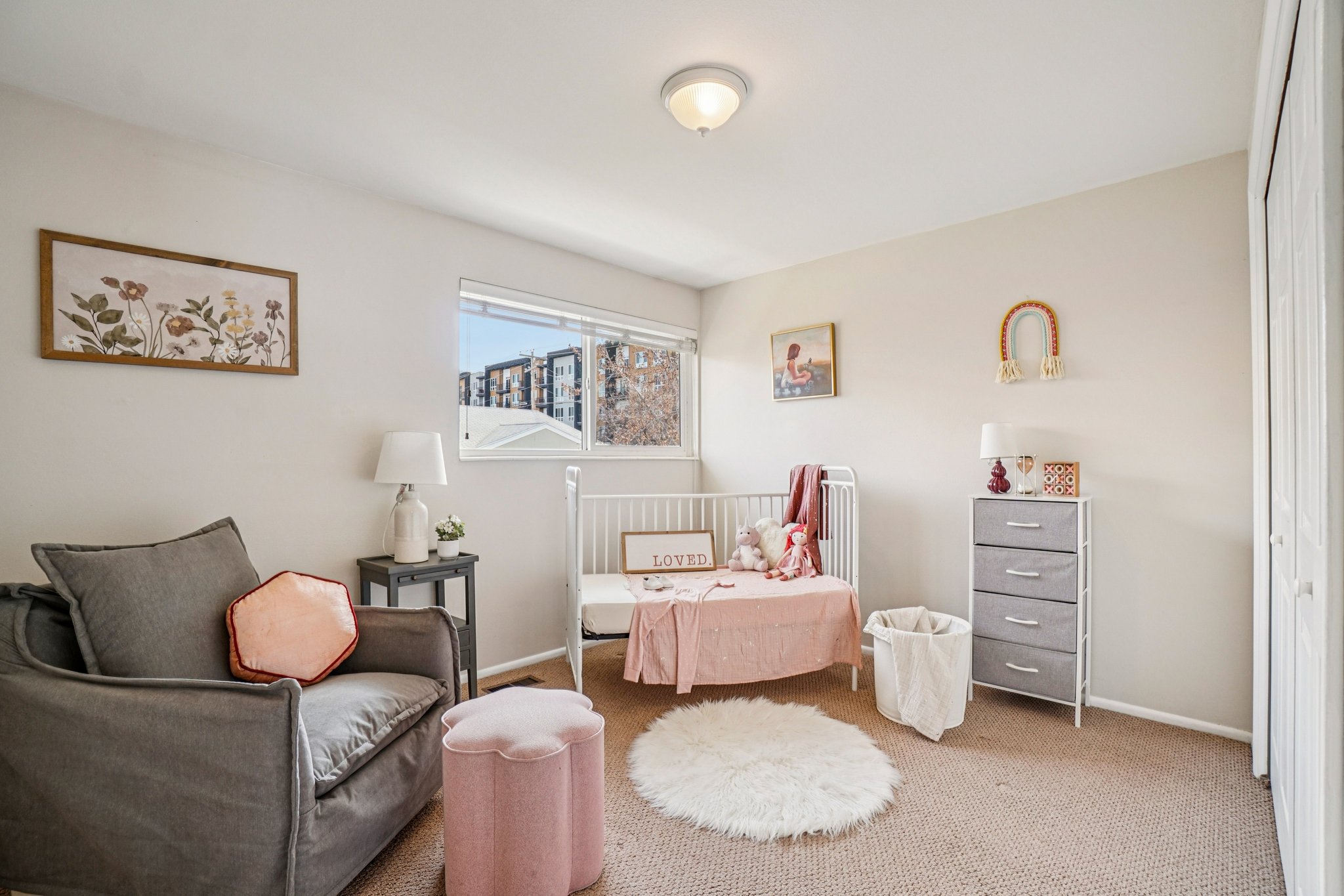 Carpeted room featuring a ceiling-mounted light fixture, a window with exterior views, and a bi-fold closet door