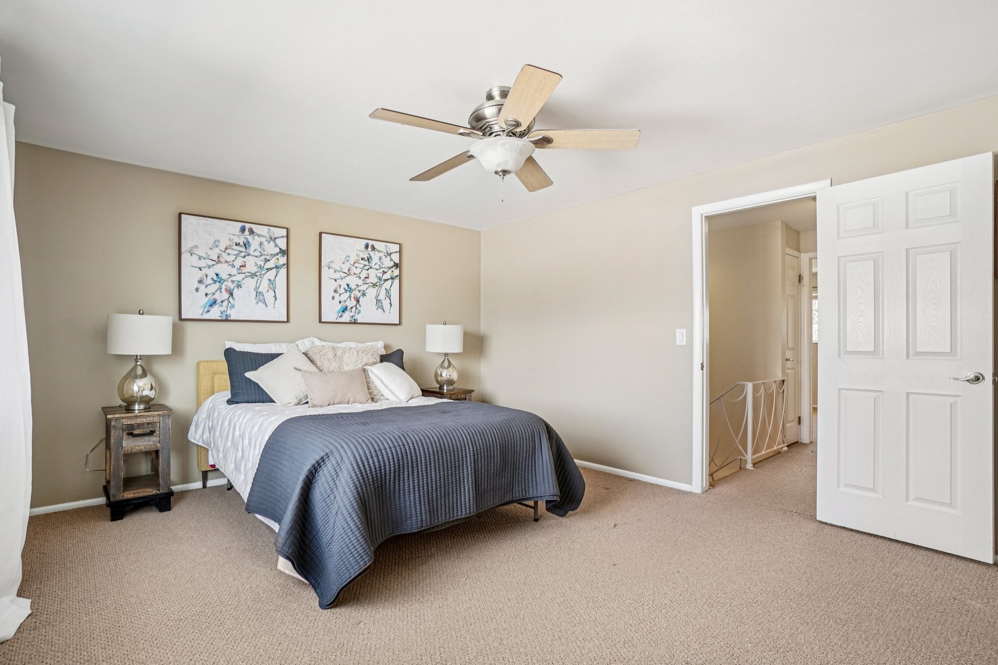 Carpeted room with neutral-toned walls, featuring a ceiling fan with light fixture