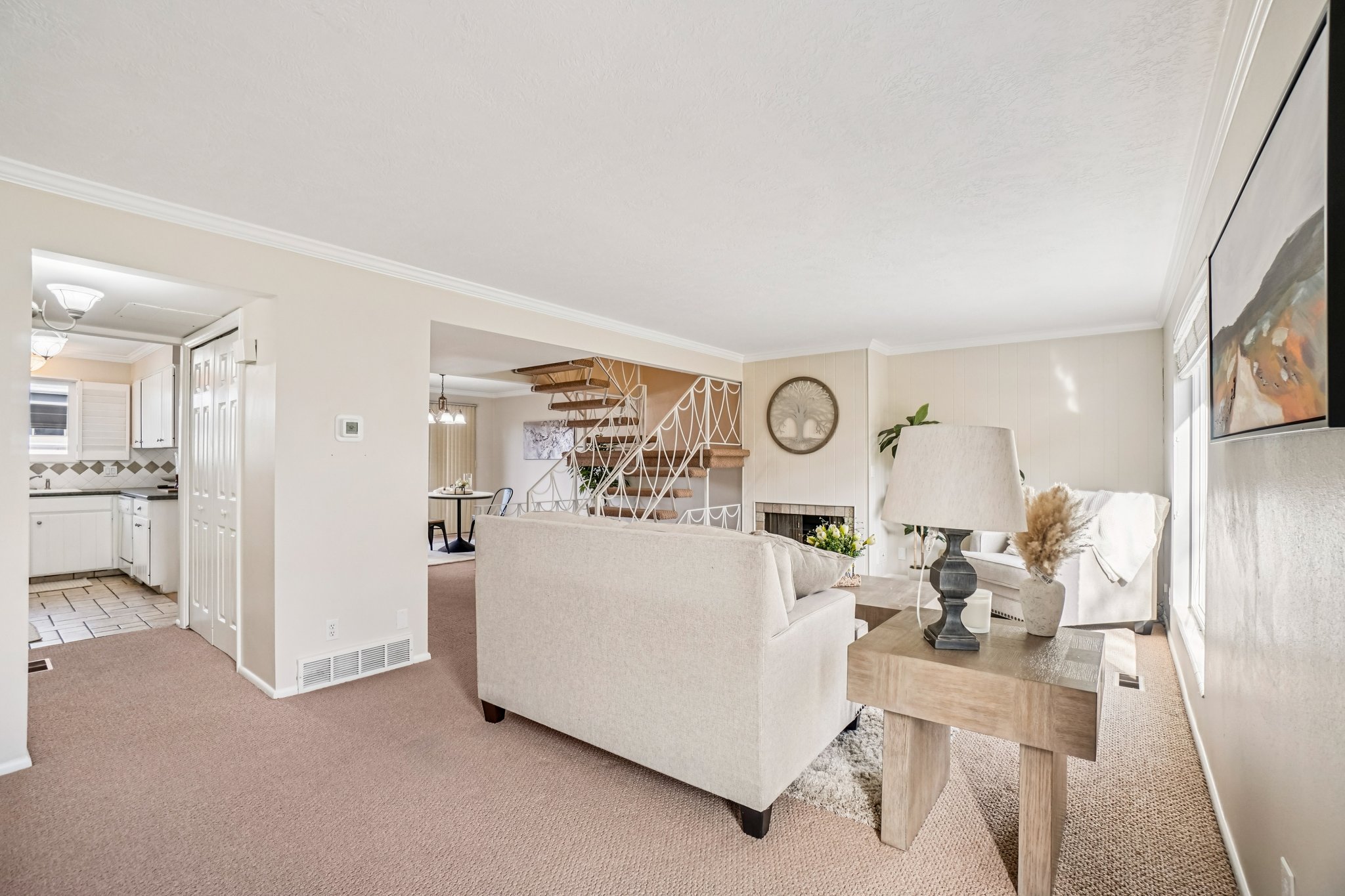 Living area featuring neutral wall tones, crown molding, and carpet flooring
