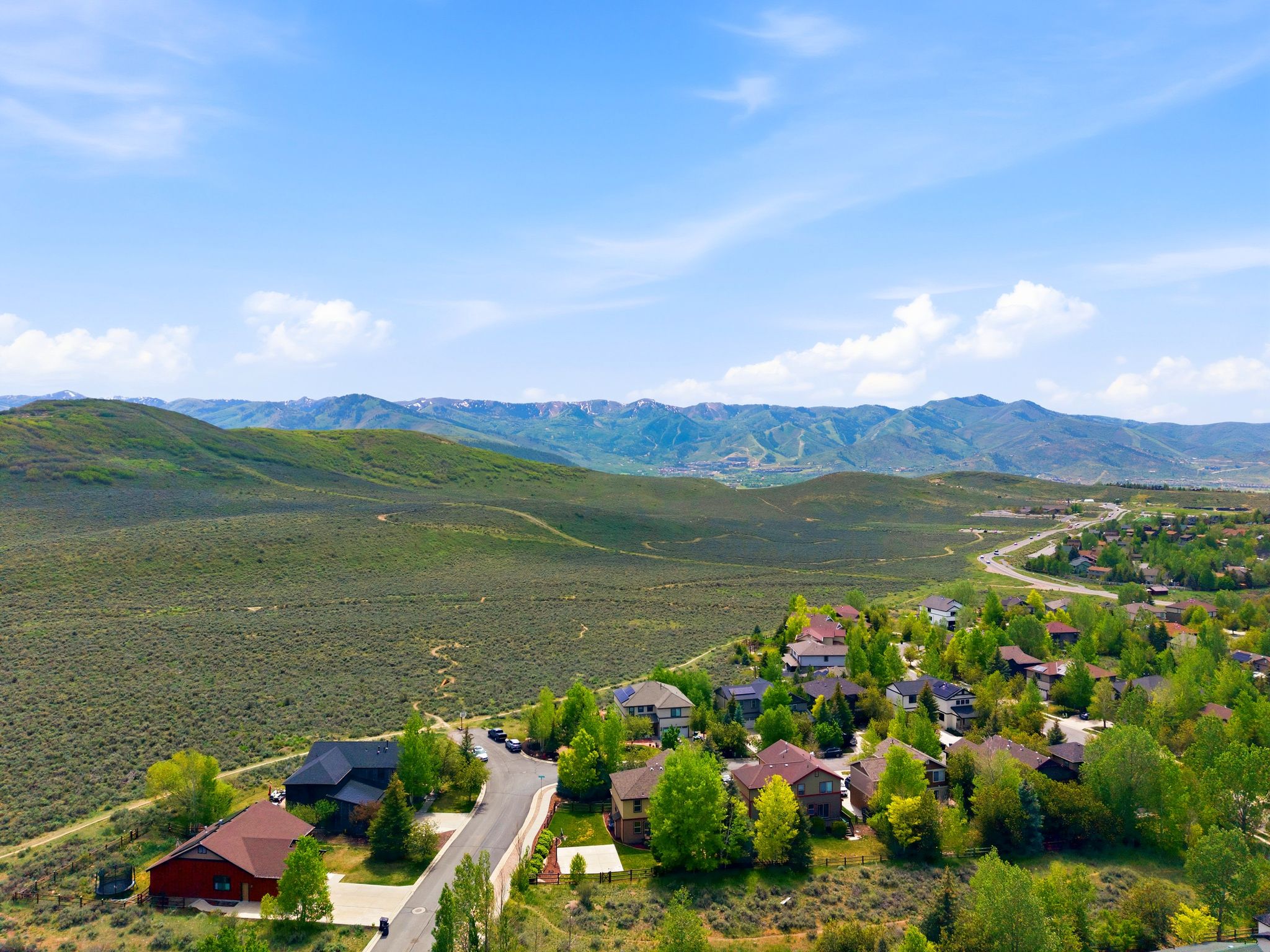 Residential development featuring diverse architectural styles, mature trees, and mountainous terrain