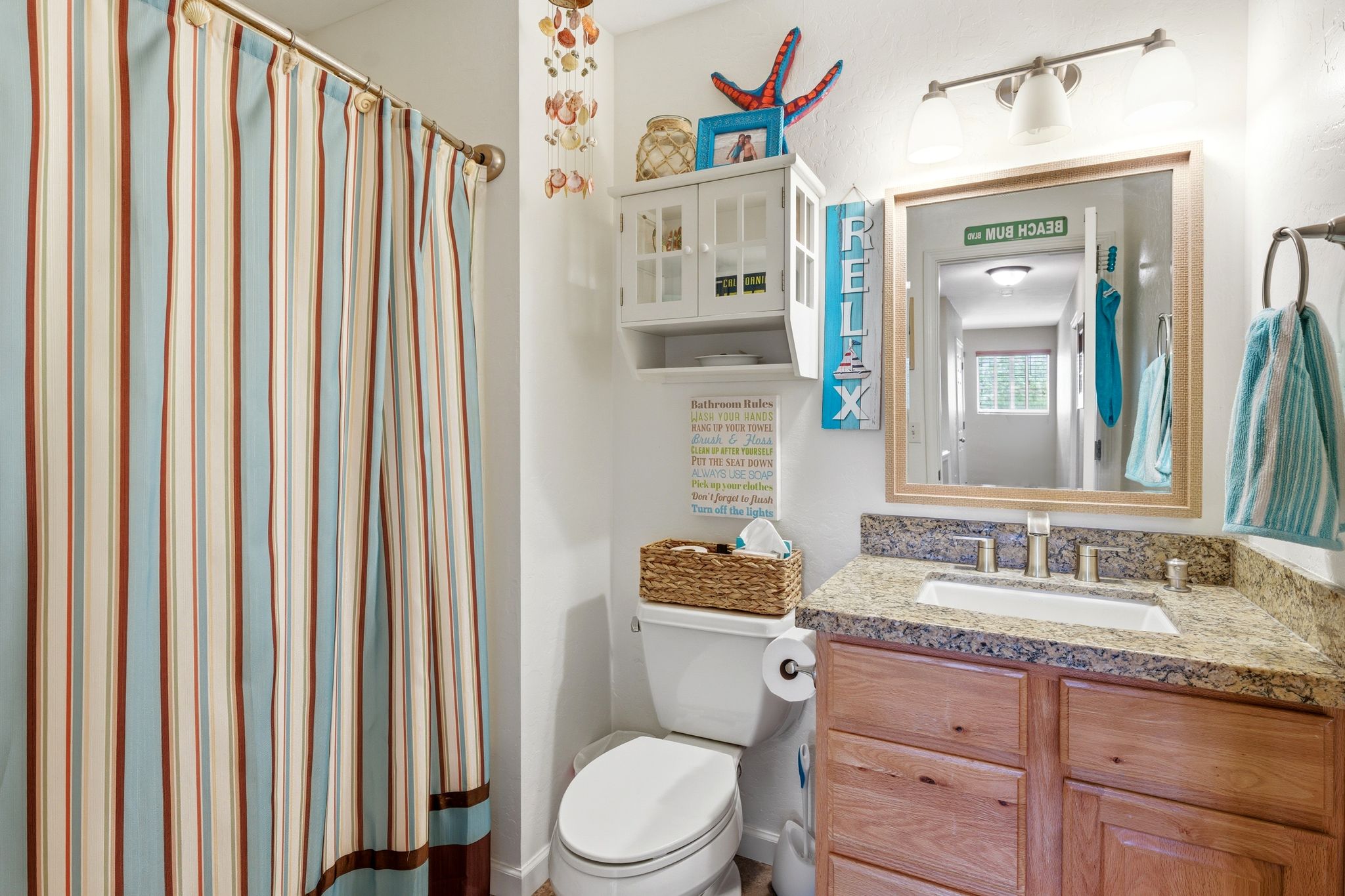 Bathroom featuring a vanity with a granite-style countertop, undermount sink, and wood-finish cabinetry
