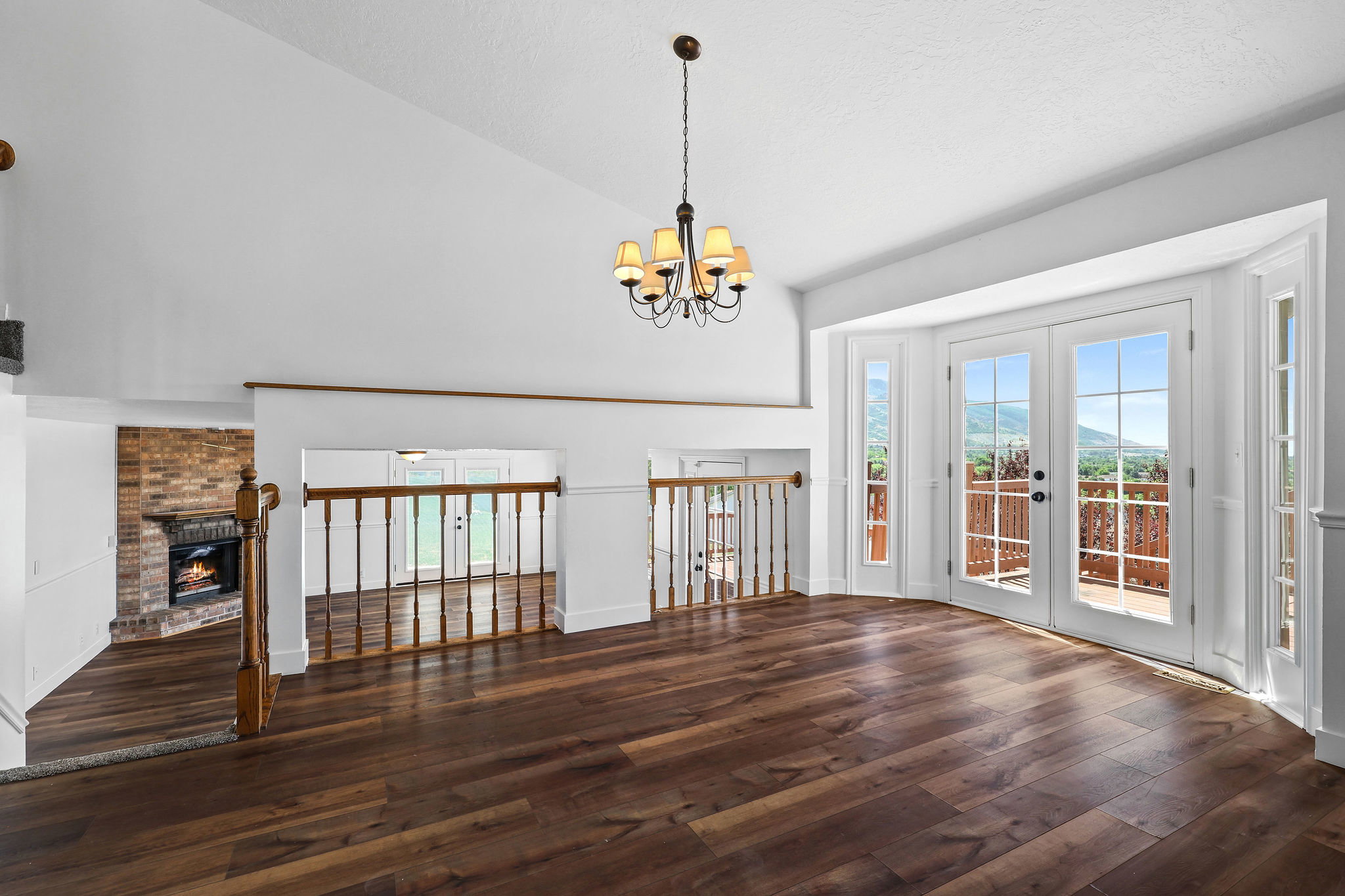 Hardwood-finish flooring throughout, complemented by a multi-light chandelier