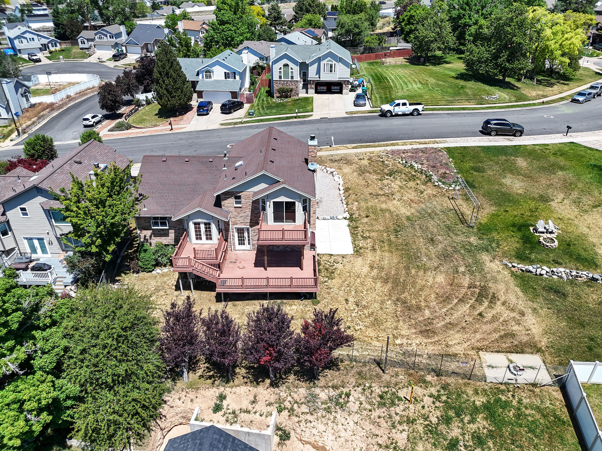 Contemporary residence featuring a multi-level deck, stone accents, and a large terraced yard