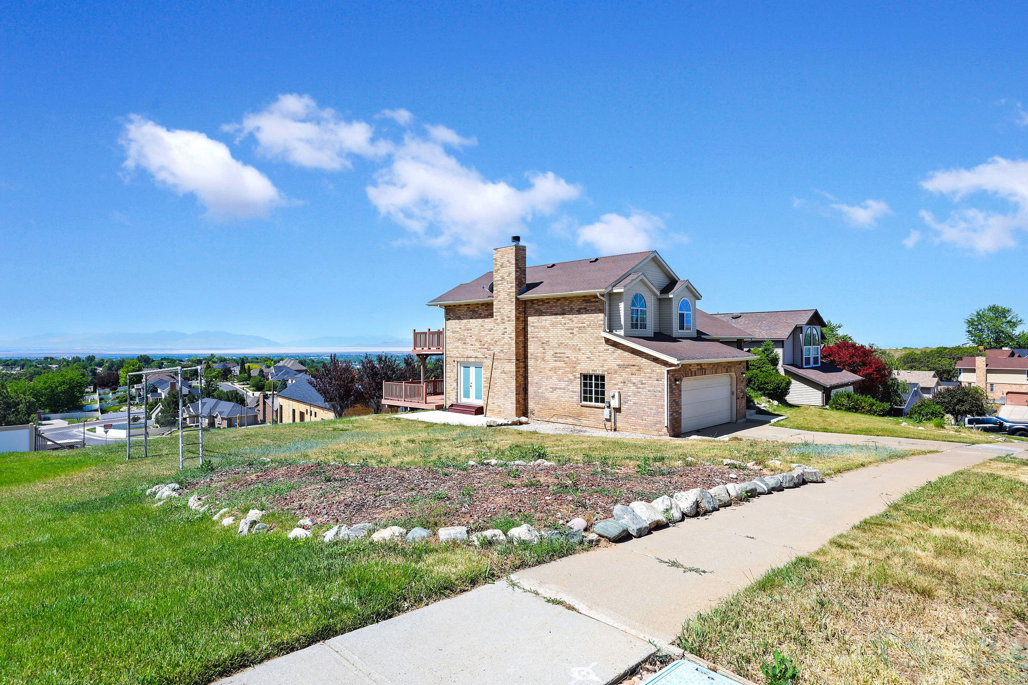 Brick exterior residence featuring a prominent chimney and an attached garage