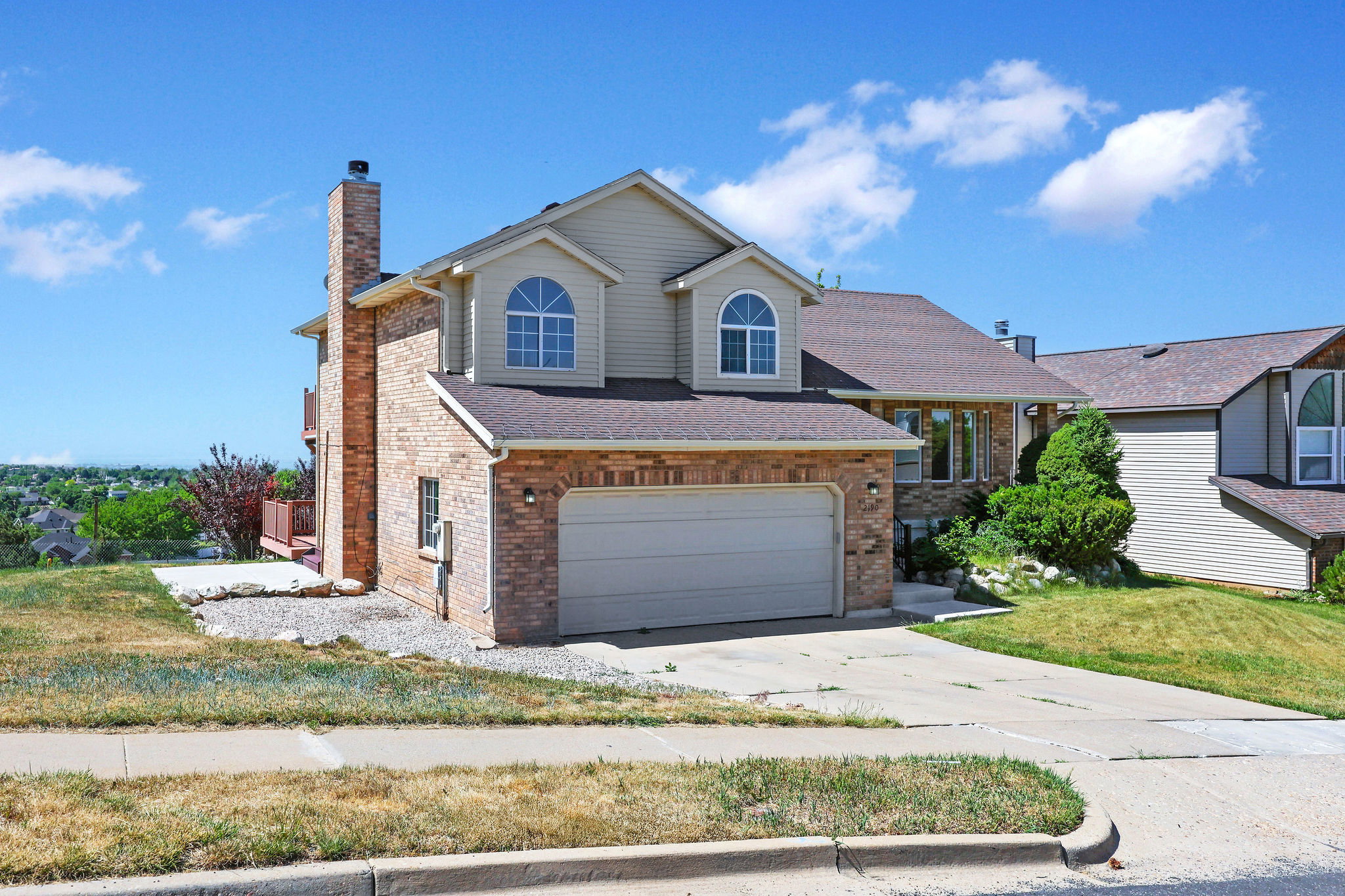 Brick and siding exterior featuring an attached two-car garage