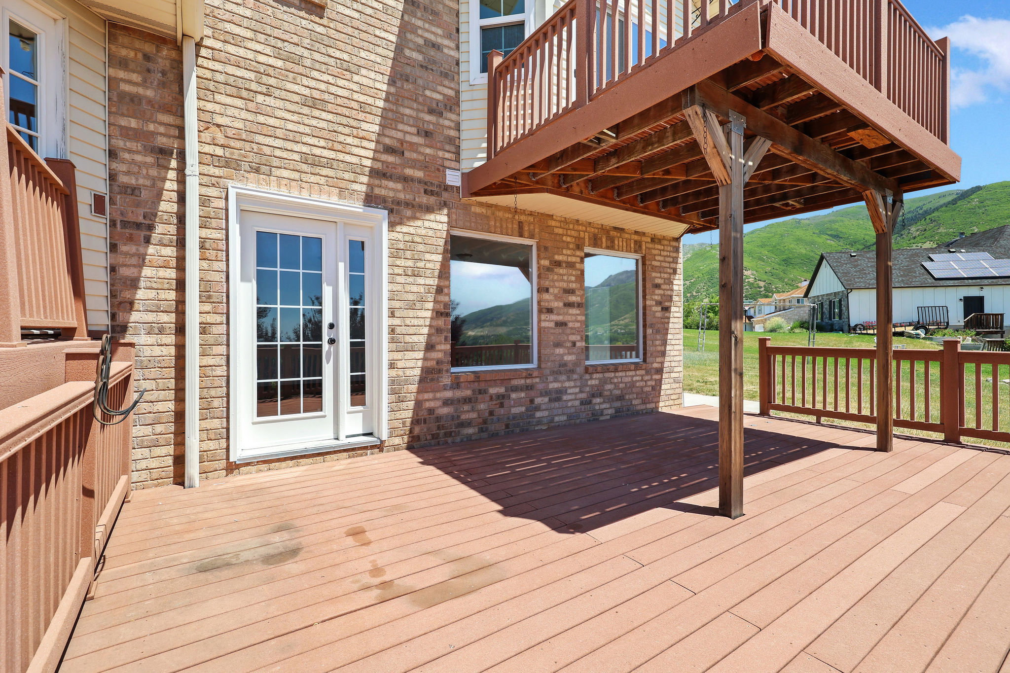 Expansive composite deck with wooden railings