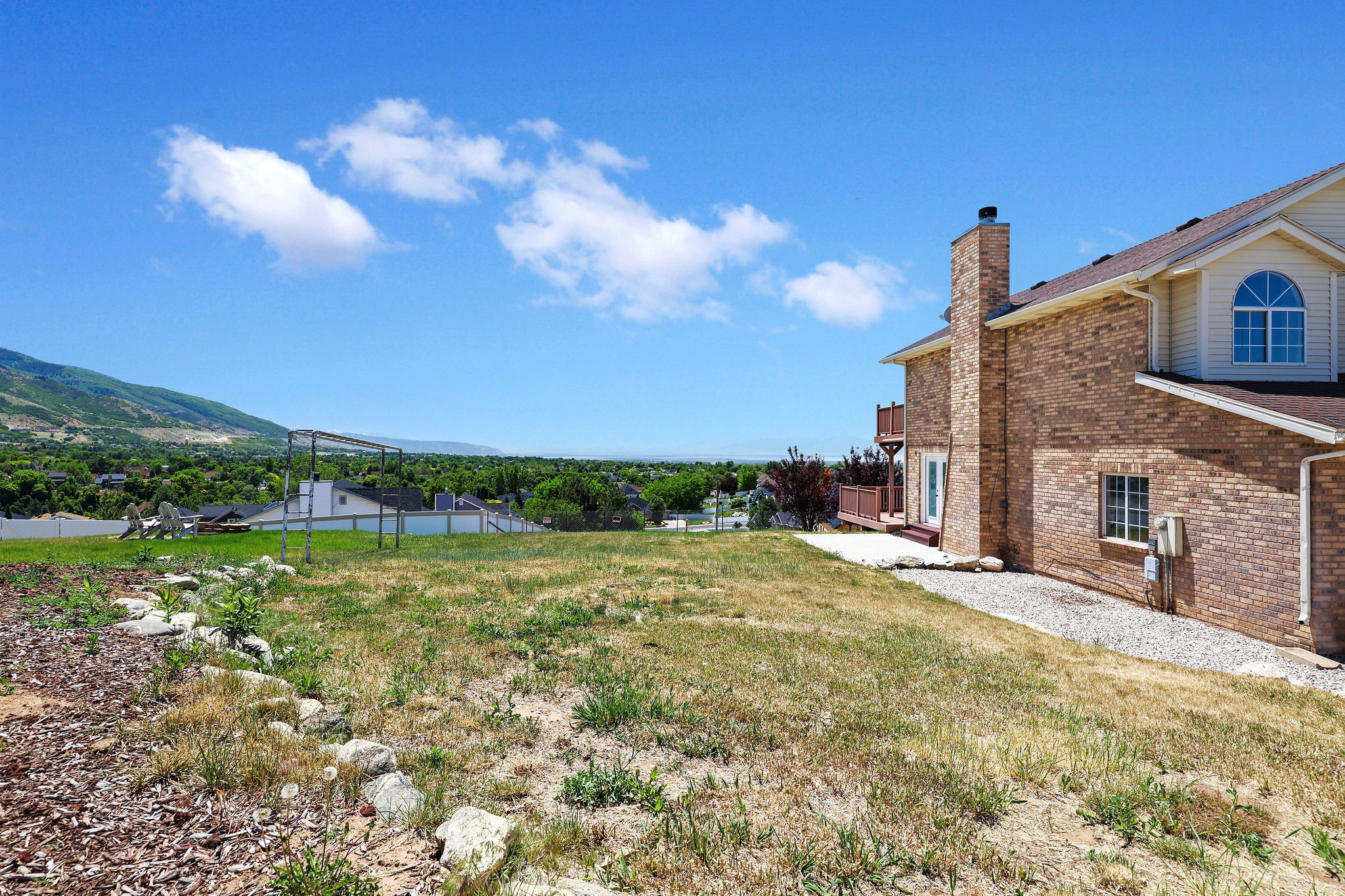 Multi-story brick residence featuring a prominent chimney and an upper-level arched window