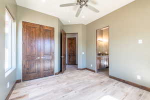 Spacious room featuring wood-finish flooring, dark wood trim, and a ceiling fan with integrated lighting