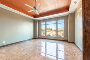 Spacious room featuring large windows, wood-finish flooring, a tray ceiling with a ceiling fan, recessed lighting, and track lighting