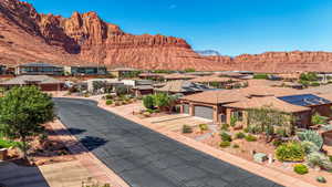 Residential community featuring single-story homes with tile roofs, solar panels, and attached garages