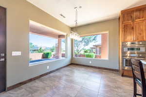 Spacious interior featuring large picture windows, wood-finish flooring, custom wood cabinetry, and built-in stainless steel appliances
