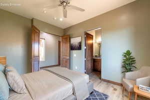 Bedroom featuring light wood-finish flooring, a ceiling fan with integrated lighting, recessed ceiling lights, and two panel doors
