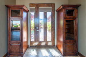 Entryway featuring a wood-panel door with sidelights, decorative frosted glass, and wood-finish trim