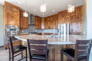 Kitchen featuring a central island with a stone countertop, built-in sink, and pendant lighting