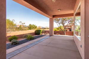 Expansive covered patio featuring concrete flooring, a decorative stamped concrete border, and recessed lighting