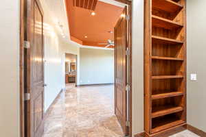 Hallway featuring built-in wood shelving and a solid wood door