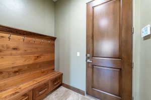Built-in wood-finish storage bench with integrated drawers and coat hooks