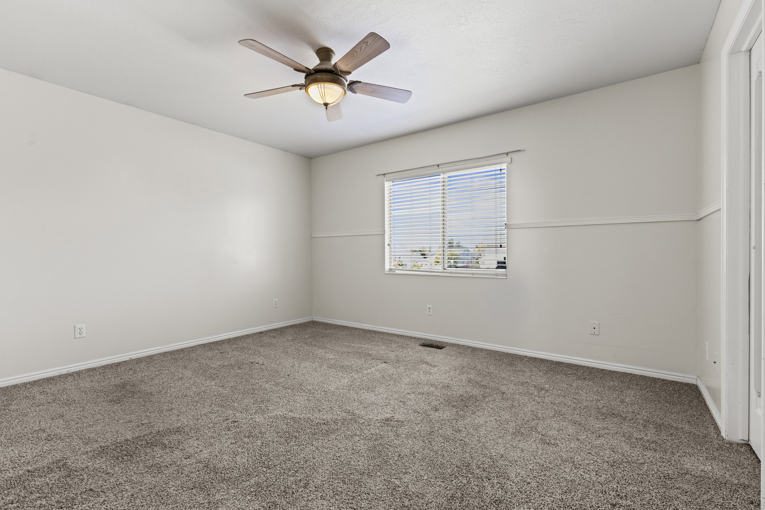 Spacious room featuring neutral carpeting and light-colored walls