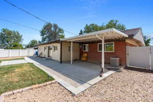 Rear exterior with a covered patio featuring string lights, a concrete patio, and a red brick facade