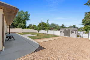 Expansive backyard featuring a concrete patio, gravel area, and a lawn space