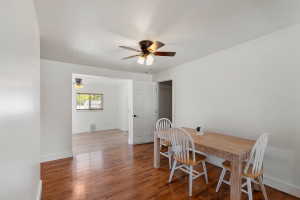 Hardwood flooring throughout, white baseboards, and ceiling fan with integrated lighting