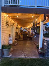 Covered outdoor living area with string lighting and concrete patio flooring