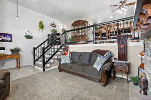 Split-level interior featuring a stone-clad fireplace and a staircase with wrought iron balusters