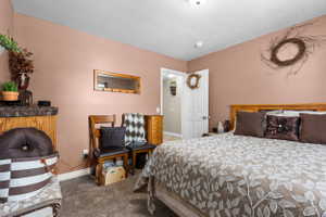 Carpeted bedroom with a wood headboard and warm-toned walls