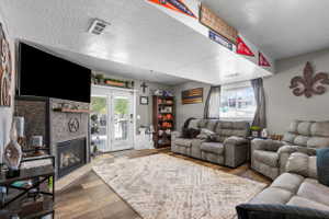 Living area featuring a contemporary fireplace with stone surround, wood mantel, and integrated entertainment space
