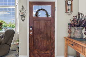 Rich wood-finish entry door with a frosted glass panel and smart lock system