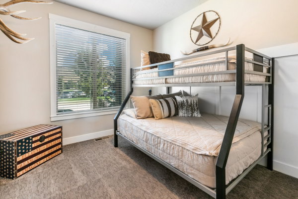 Spacious room featuring a large window with blinds, light-toned walls, and plush carpeting