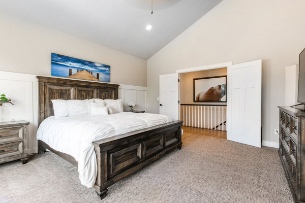 Vaulted ceilings compliment this carpeted room featuring wainscoting and neutral wall tones