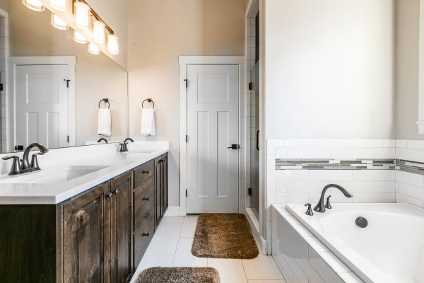 Bathroom featuring a double vanity with dark wood cabinetry, white countertops, and dual undermount sinks
