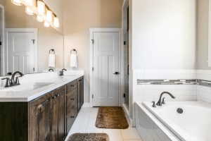 Bathroom featuring a double vanity with dark wood cabinetry, white countertops, and dual undermount sinks