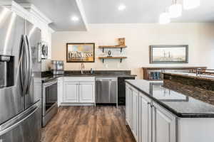 Kitchenette featuring wood-finish flooring and white shaker-style cabinetry with dark hardware