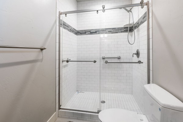 Walk-in shower with clear glass enclosure and sliding door