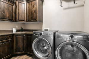 Laundry area featuring wood-finish cabinetry, a corner sink with a matte black faucet, and a light-toned countertop