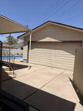 Detached garage with horizontal siding, a roll-up door, and a brown trim roofline