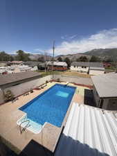 Rectangular in-ground swimming pool featuring concrete decking, integrated steps with handrails, and a diving board