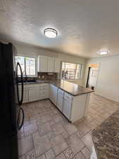 Kitchen featuring light-toned cabinetry, granite-finish countertops, and a central island