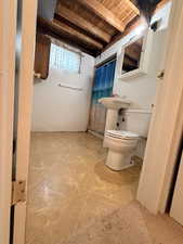 Bathroom featuring a pedestal sink, white toilet, and recessed medicine cabinet