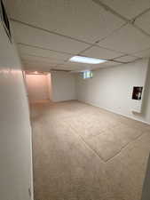 Carpeted room featuring a drop ceiling with recessed lighting
