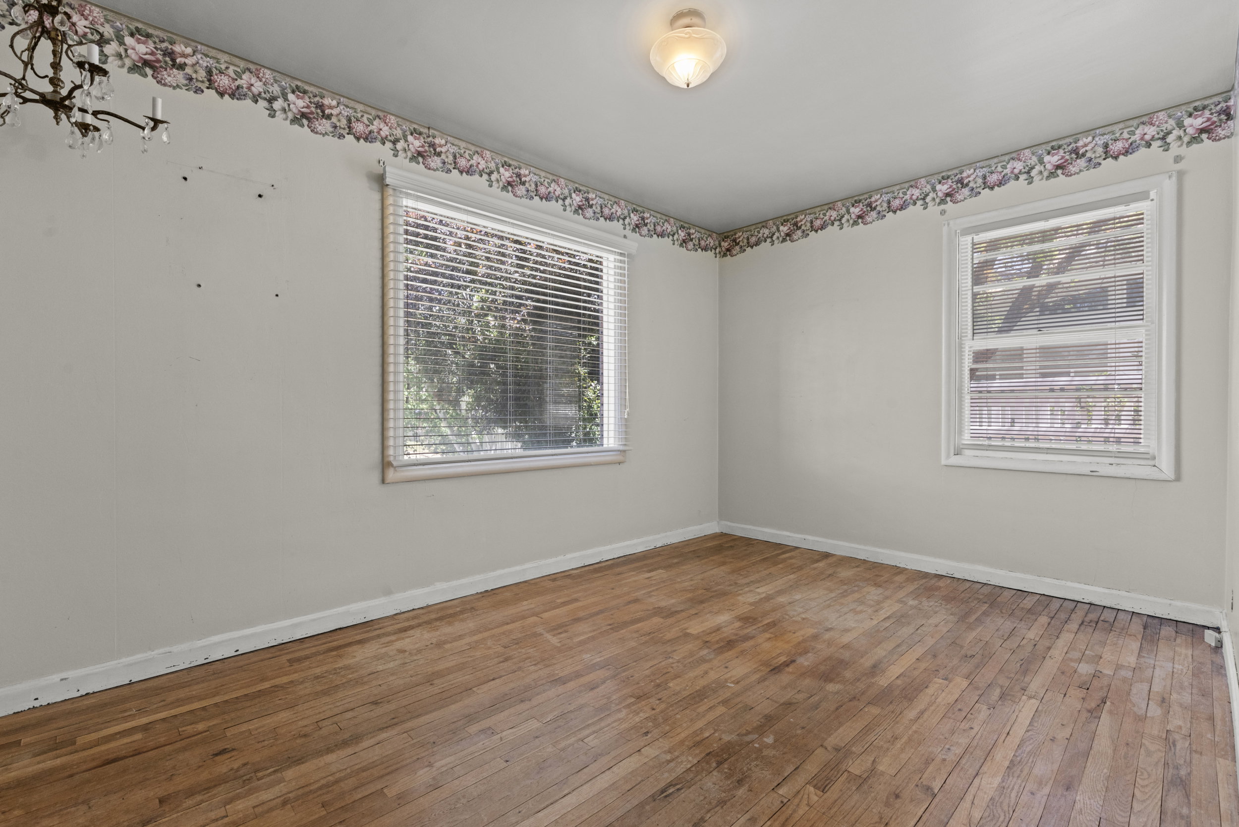 Wood-finish flooring throughout, complemented by two windows with horizontal blinds